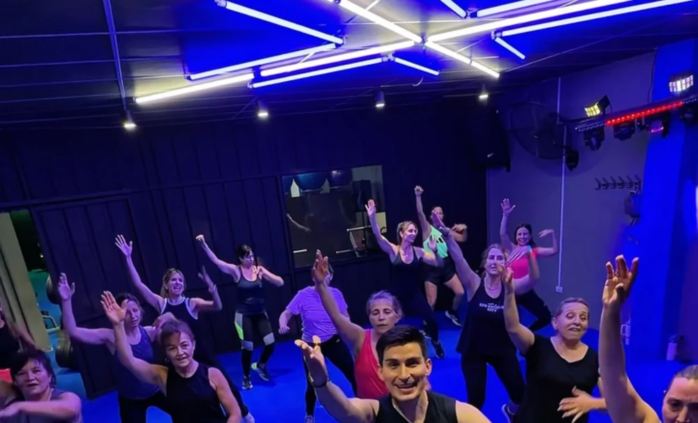 Clase grupal en Body Global con participantes y luces azules
